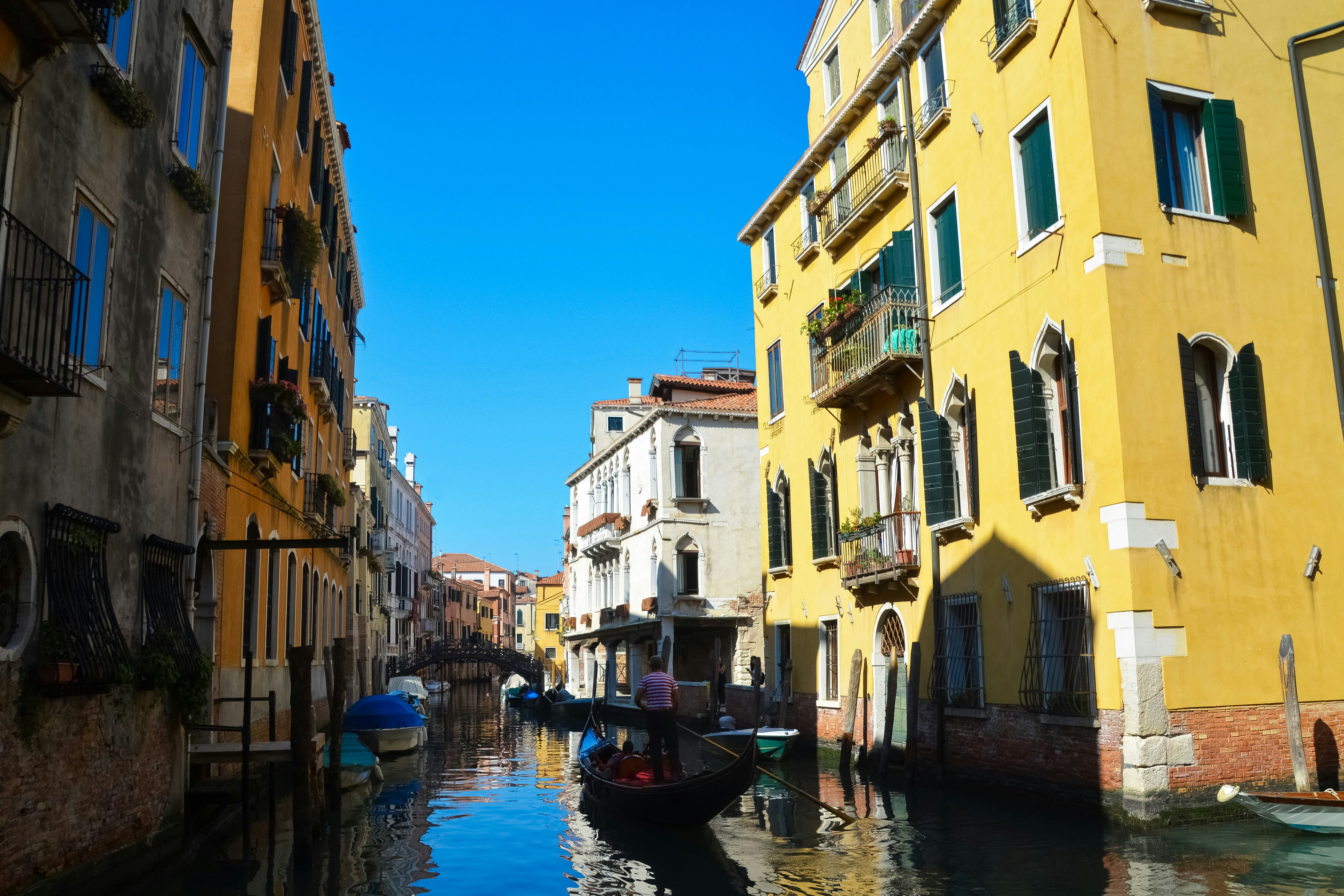 boat on river between buildings during daytime